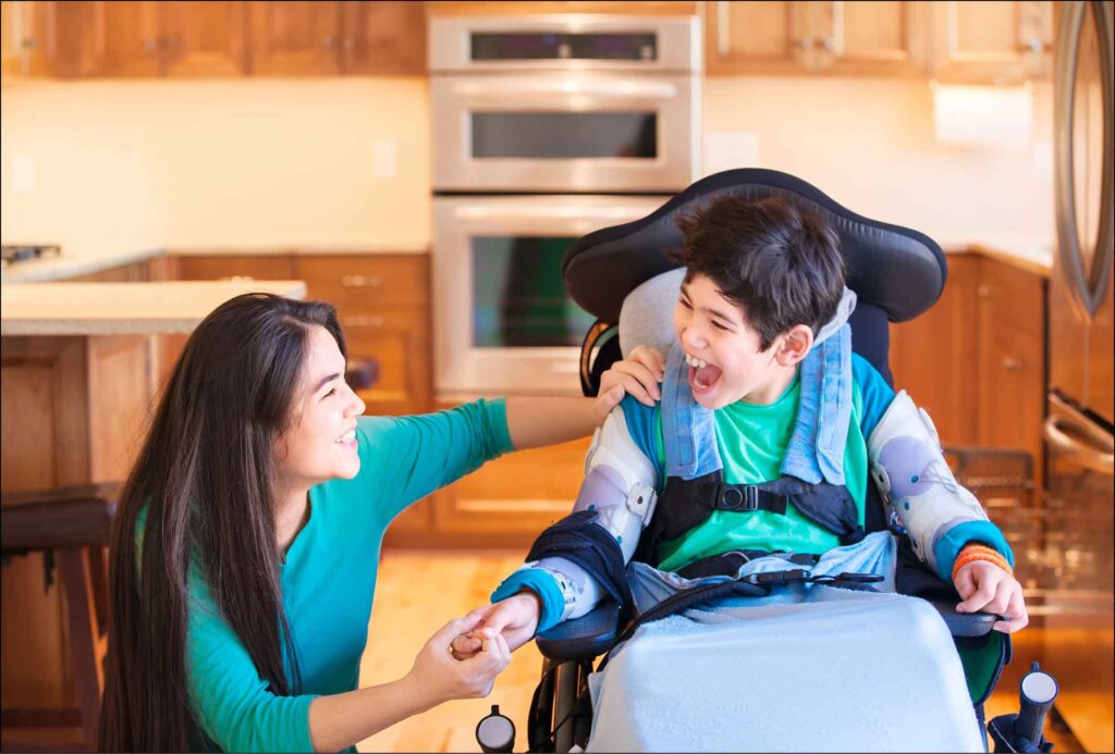 Ein Heilerziehungspfleger betreut ein Kind im Rollstuhl.
